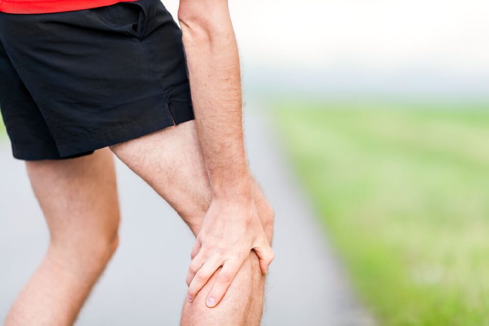 Runner holding the back of the leg because of tendon pain