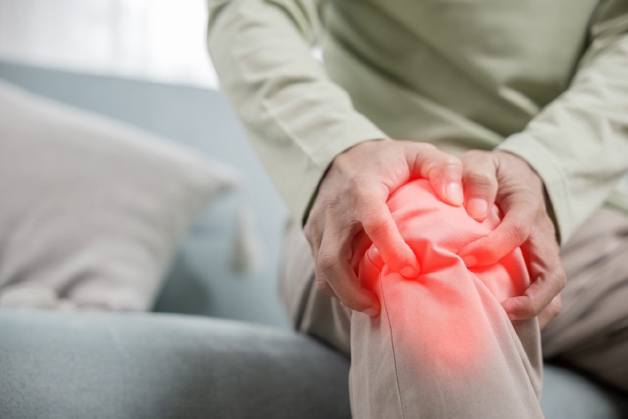 Person holding a painful knee affected by osteoarthritis