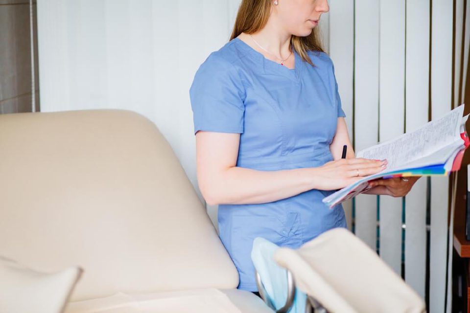A clinician reviewing patient notes in a consultation room